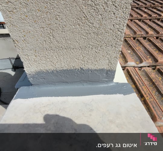 גג עם רעפים חומים ואיטום אפור סביב עמוד